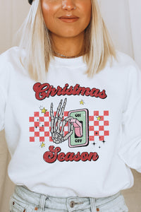 a woman wearing a white sweatshirt with a christmas season design on it