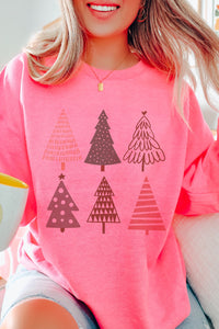 a woman wearing a pink shirt with christmas trees on it